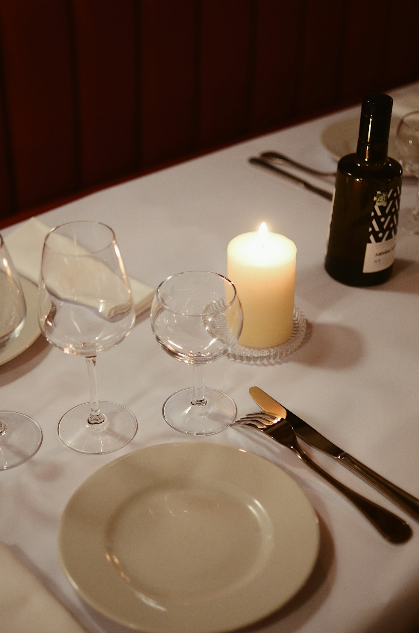 A formally set dinner table with a lit candle
