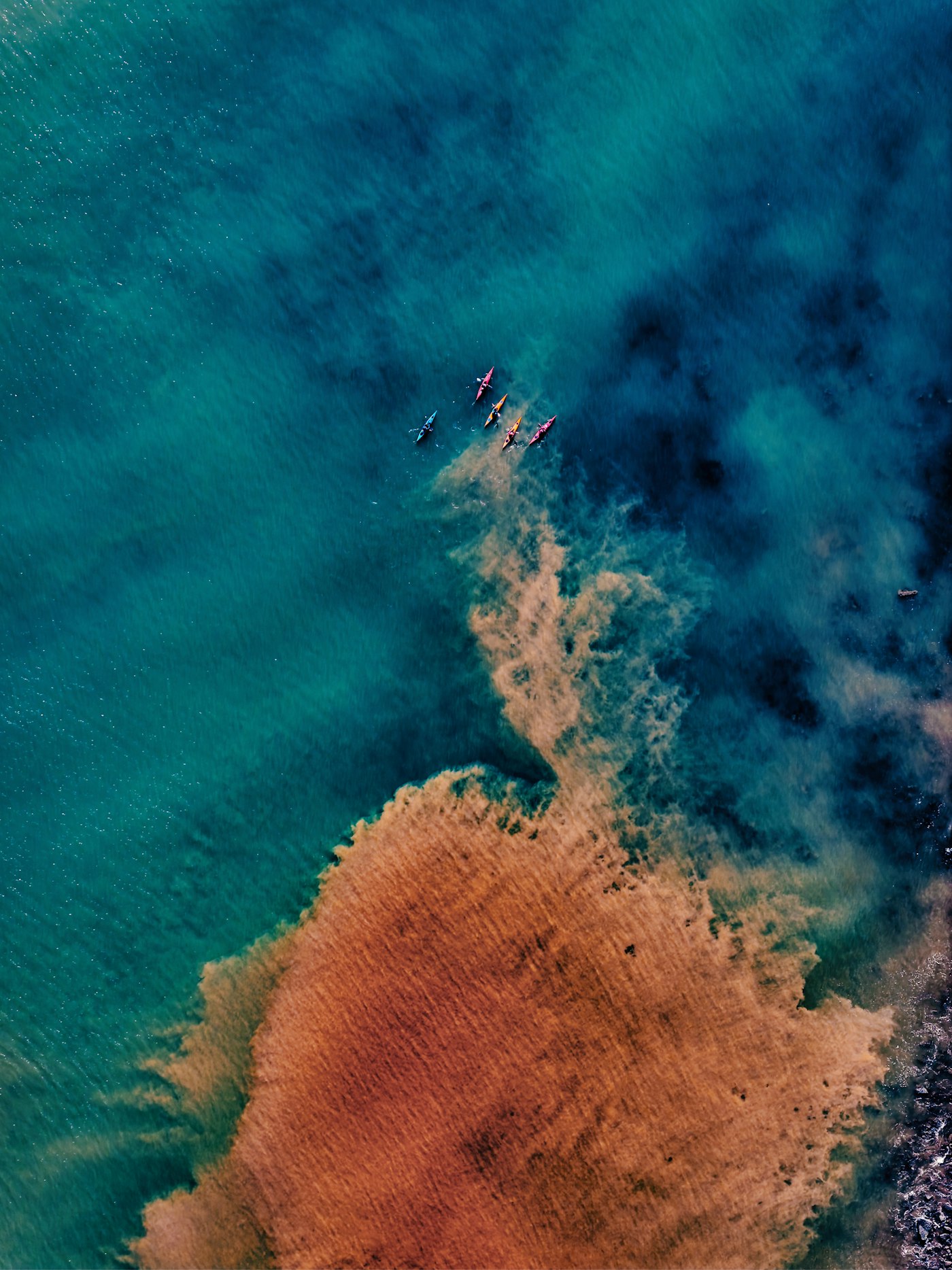Kayakers paddling through turquoise water