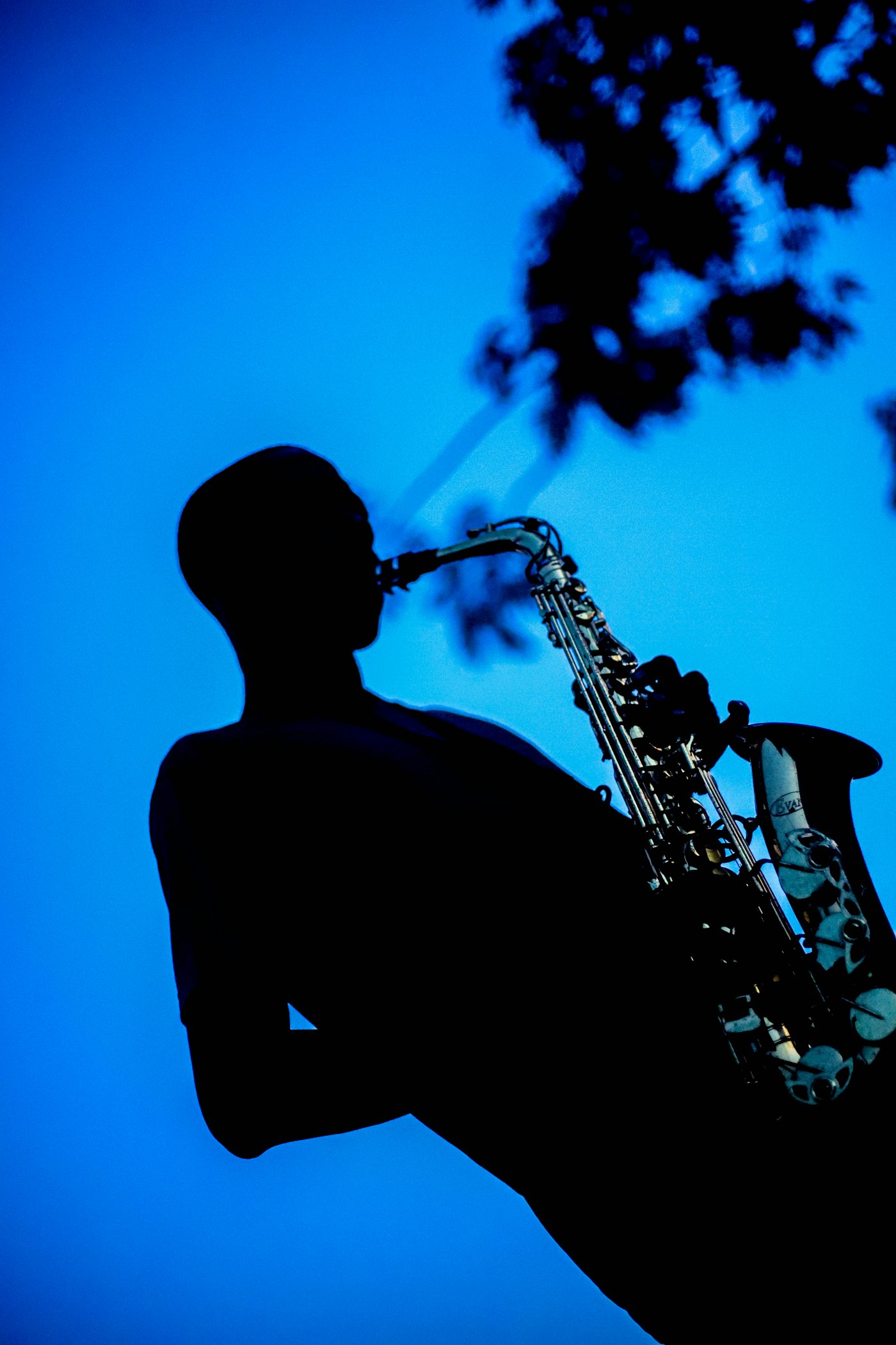 Silhouette of a saxophonist in a dim jazz bar